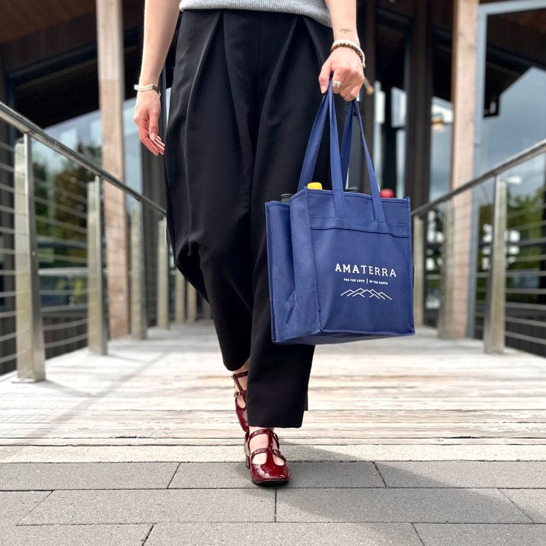 Woman walking out of Amaterra Winery Portland with branded Amaterra bag with wine.