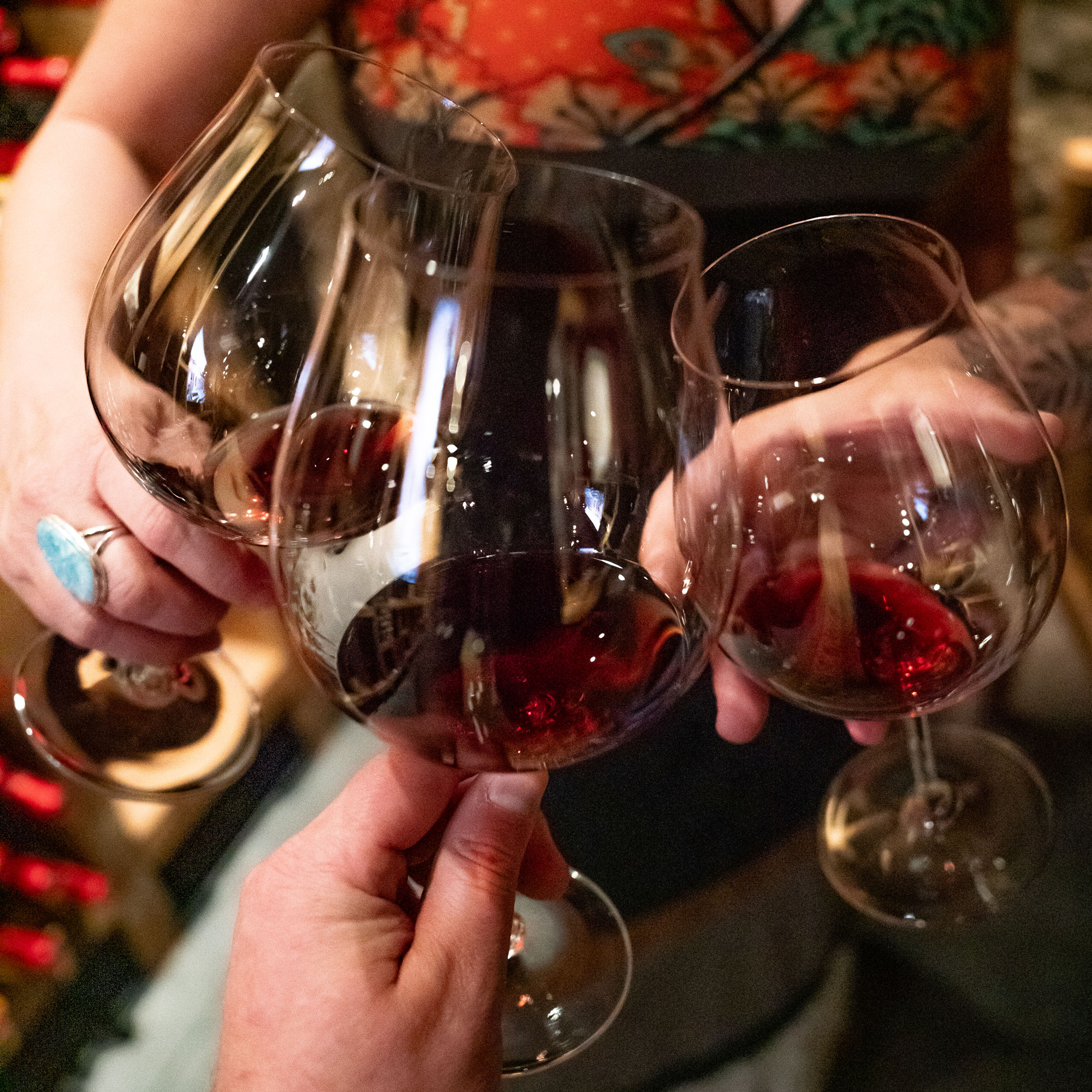 Three people clinking wine glasses